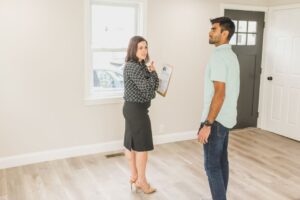 Couple reviewing mortgage papers and a home inspection checklist at a kitchen table.