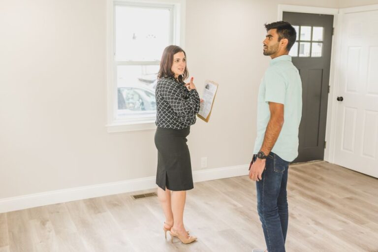 Couple reviewing mortgage papers and a home inspection checklist at a kitchen table.